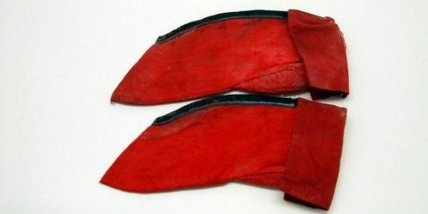 清末裹脚女子睡觉时所穿的睡袜，颜色为红色，拷边为黑色，针脚细腻，十分罕见